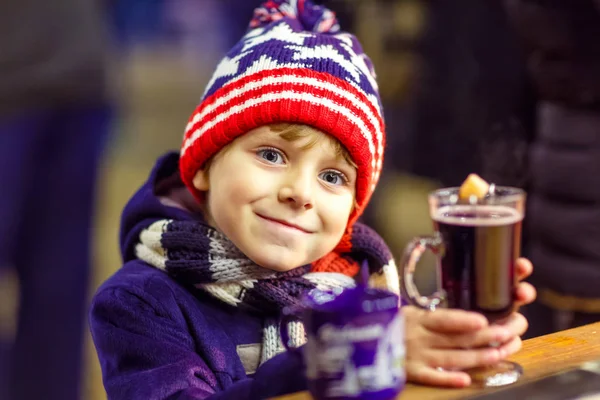 Niño pequeño con chocolate caliente en el mercado de Navidad —  Fotos de Stock