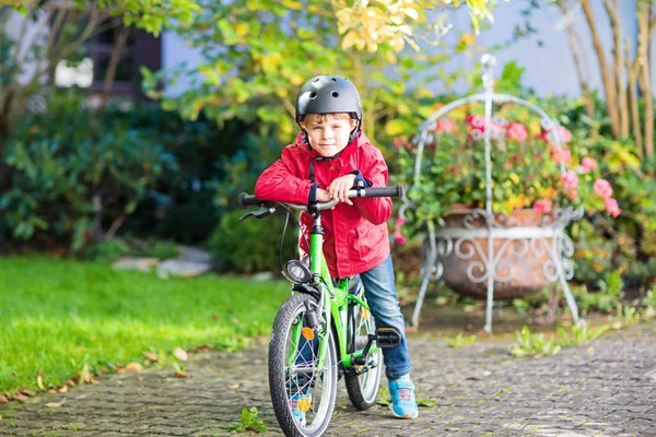 Petit garçon en casque chevauchant avec son vélo dans la ville — Photo