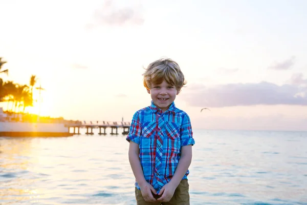 Niño pequeño al atardecer cerca del océano — Foto de Stock