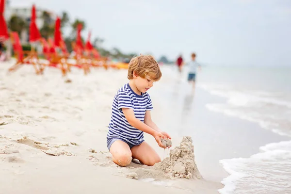 작은 꼬마 소년 재미 모래 성을 구축 — 스톡 사진