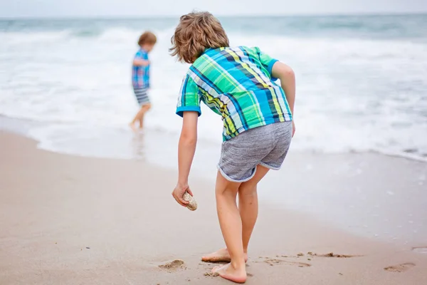 Dwa małe dzieci chłopców uruchomiona na plaży oceanu — Zdjęcie stockowe