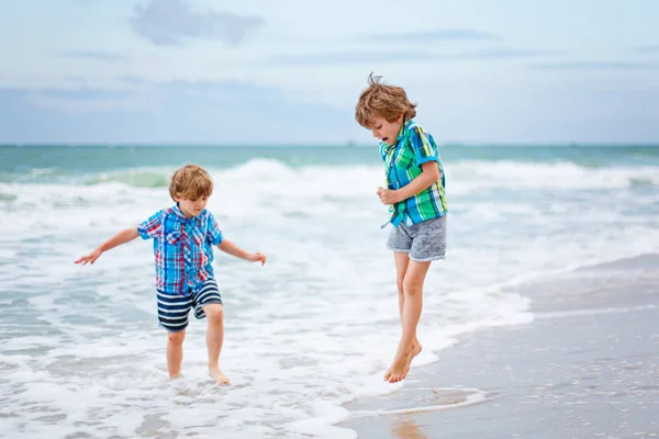 Deux petits garçons courent sur la plage de l'océan — Photo