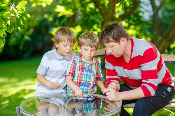 两个小家伙男孩和父亲在一起玩出错西洋跳棋游戏 — 图库照片
