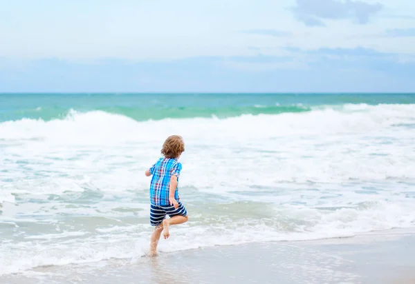 Little kid boy running on the beach of ocean — Stock Photo, Image