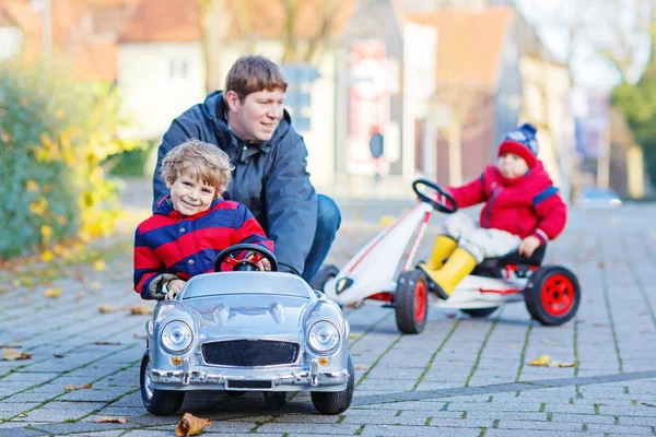 Deux petits garçons et père jouant avec la voiture, à l'extérieur — Photo