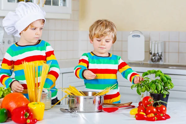 Zwei kleine Jungen kochen Nudeln mit Gemüse — Stockfoto