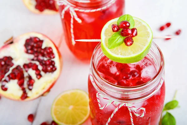 Två glas med rött granatäpplejuice, citron och mynta. — Stockfoto