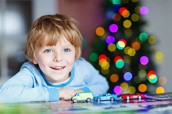 車と自宅のおもちゃで遊んで少しの金髪の子供 — ストック写真