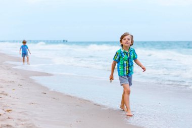 İki küçük okyanus plaj üzerinde çalışan çocuklar çocuk