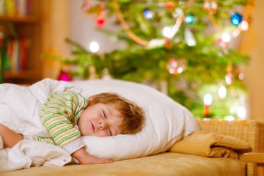 Noel ağacının altında uyuyan küçük şirin çocuk çocuk
