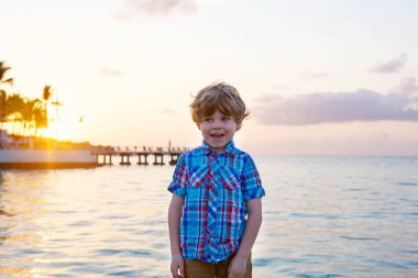 Küçük çocuk çocuk Okyanusu yakın gün batımında