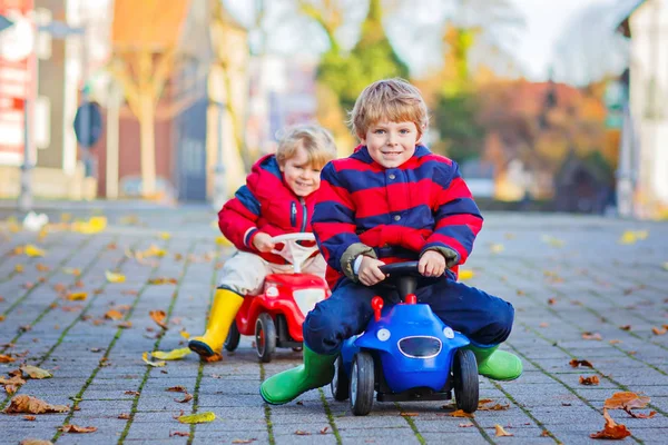 Twee kinderen weinig jongens spelen met speelgoed auto's, buiten — Stockfoto