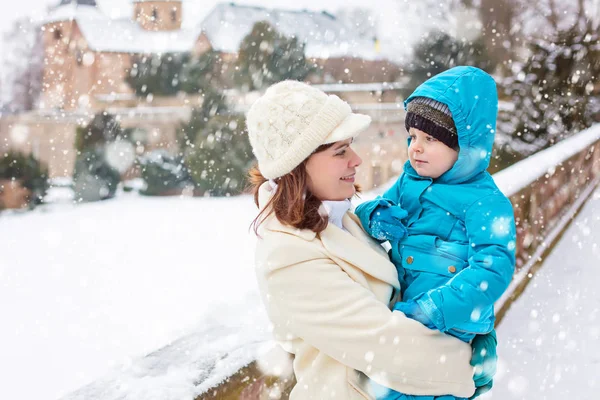 Piccolo bambino bambino ragazzo e madre divertirsi con la neve nella giornata invernale — Foto Stock