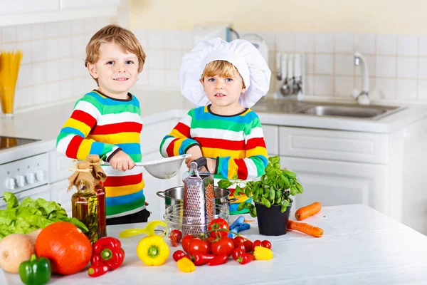 Zwei kleine Jungen kochen Nudeln mit Gemüse — Stockfoto