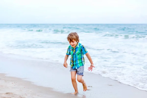 Little kid boy running on the beach of ocean — Stock Photo, Image