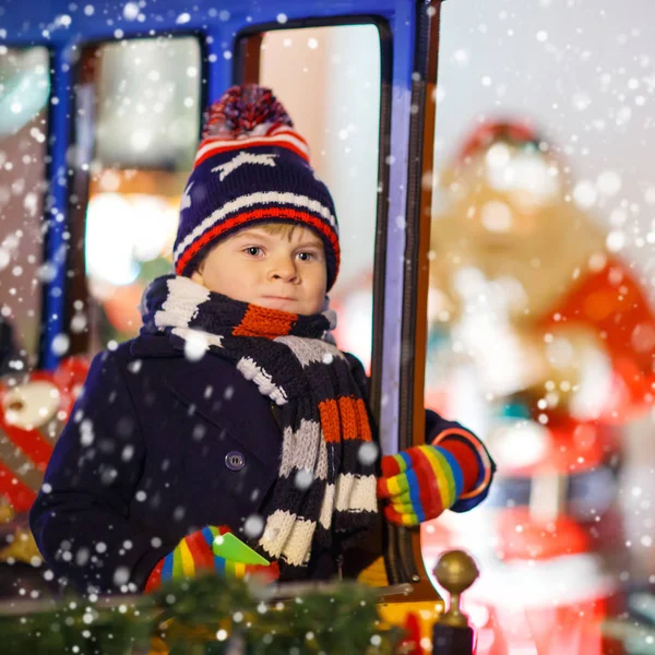 Küçük çocuk çocuğa Noel pazarı, atlıkarınca — Stok fotoğraf