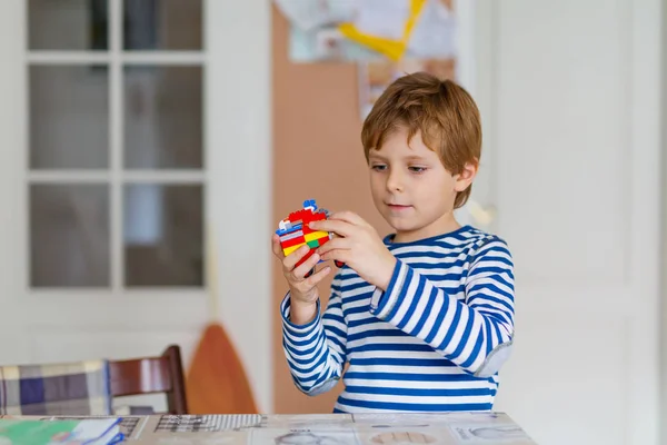 Niño de la escuela jugando con un montón de pequeños bloques de plástico de colores — Foto de Stock