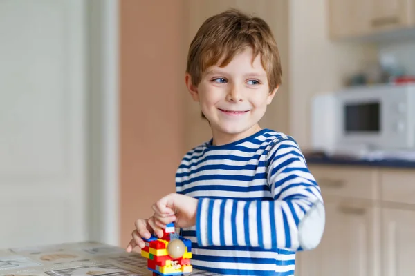 Niño de la escuela jugando con un montón de pequeños bloques de plástico de colores — Foto de Stock