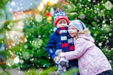 İki küçük çocuk Noel piyasasında sarılma