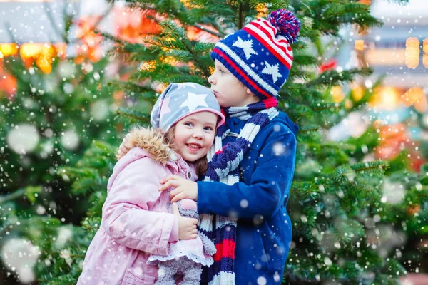 Двое маленьких детей обнимаются на Рождественской ярмарке — стоковое фото