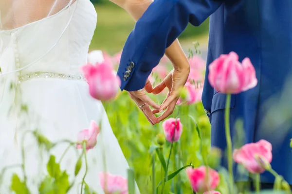 Pareja feliz boda en campo de amapola rosa — Foto de Stock