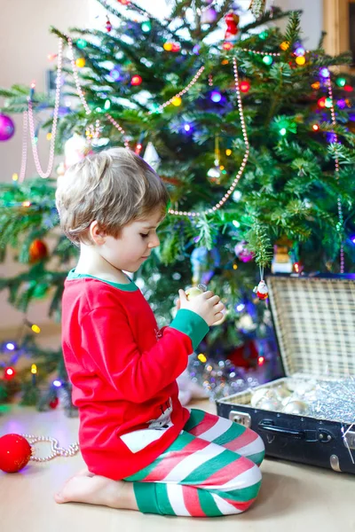 Niño decorando el árbol de Navidad con bolas —  Fotos de Stock
