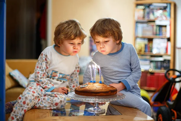 Niños pequeños niños gemelos celebrando cumpleaños y soplando velas en la torta —  Fotos de Stock