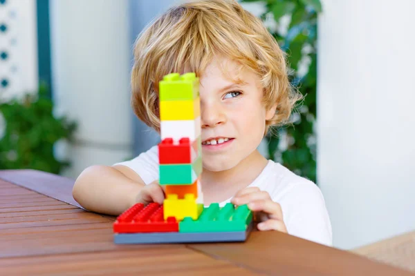 Mały chłopiec dziecko bawi się kolorowe bloki z tworzyw sztucznych — Zdjęcie stockowe
