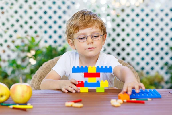 Liten unge pojke leker med färgglada plast block — Stockfoto