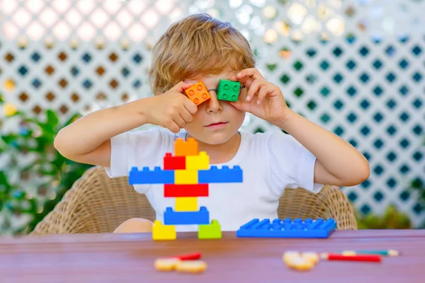 Kleine jongen jongen spelen met kleurrijke kunststof blokken — Stockfoto