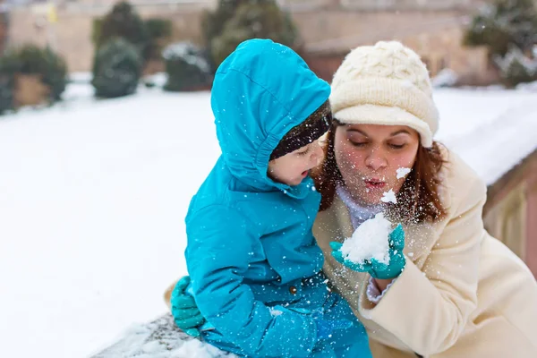 Pequeño niño niño y madre divirtiéndose con la nieve en el día de invierno — Foto de Stock