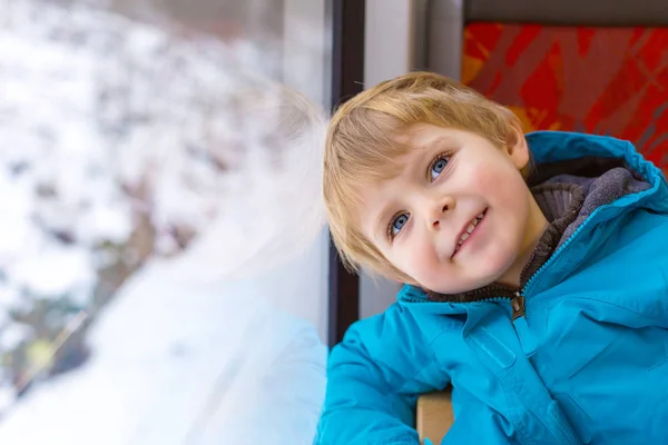 Schattige kleine peuter jongen kijkt uit raam van de trein — Stockfoto