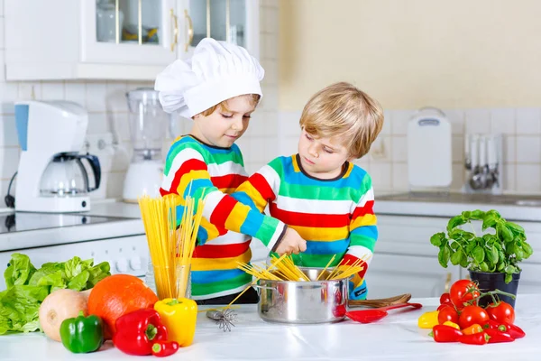 Két kis gyerek fiú főzés tészta zöldségekkel — Stock Fotó