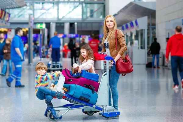 Mother and two little kids children at the airport, traveling together — Stock Photo, Image