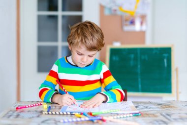 Mutlu okul çocuğu evde ödevini yapıyor.