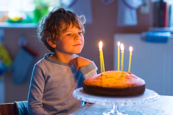 Kleine jongen jongen viert zijn verjaardag en blazen kaarsen op taart — Stockfoto