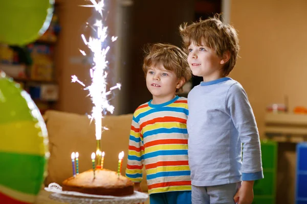 Little kid boys twins celebrating birthday and blowing candles on cake — Stock Photo, Image