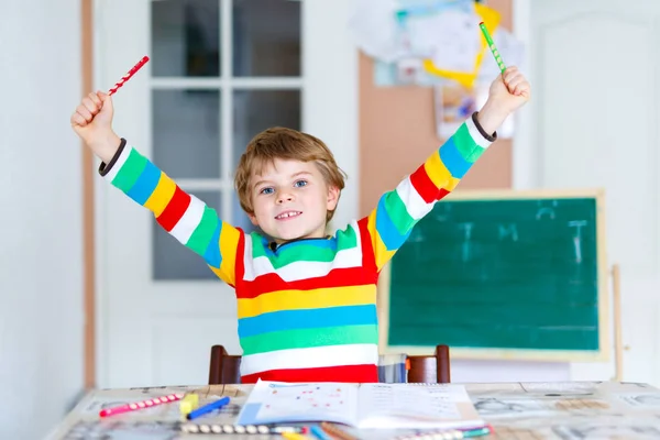 Happy school kid boy at home making homework — Stock Photo, Image