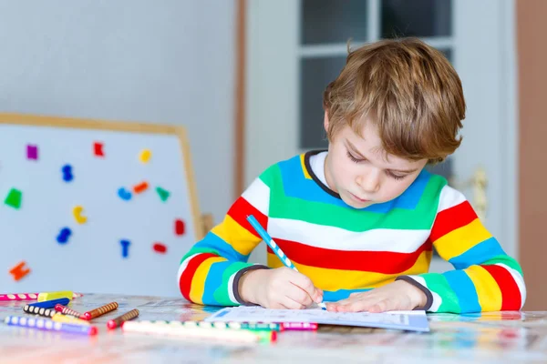 Šťastný školní kluk doma dělat domácí úkoly — Stock fotografie