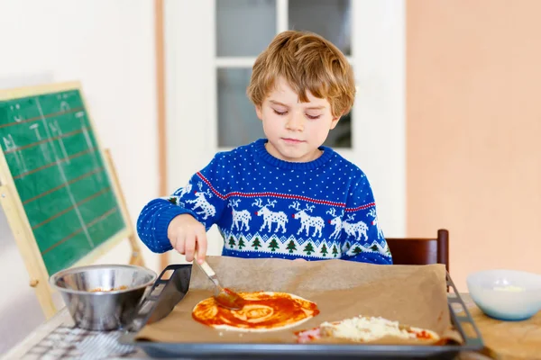 Menino bonito fazendo pizza italiana com legumes frescos — Fotografia de Stock