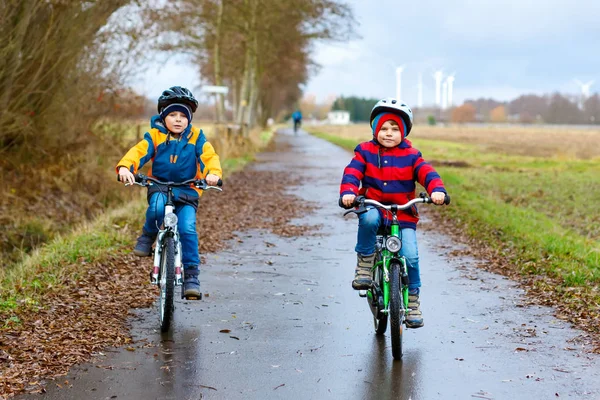 Little preschool children in helmets riding on bicycle — Stock Photo, Image