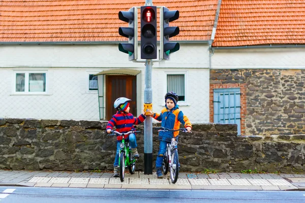 Two kids boys biking and waiting on traffic light — Stock Photo, Image