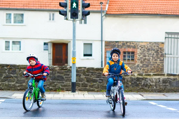 Two kids boys biking and waiting on traffic light — Stock Photo, Image