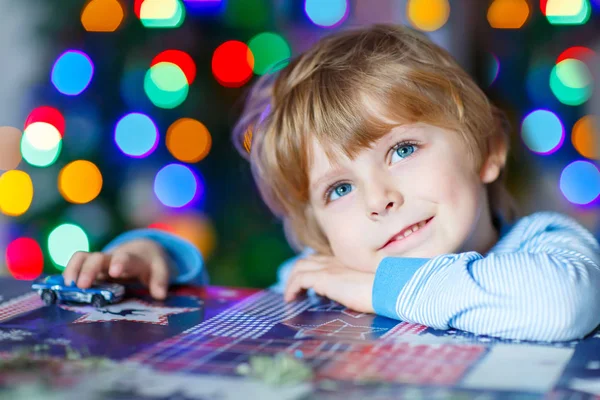 Lilla blonda barn leker med bilar och leksaker hemma — Stockfoto
