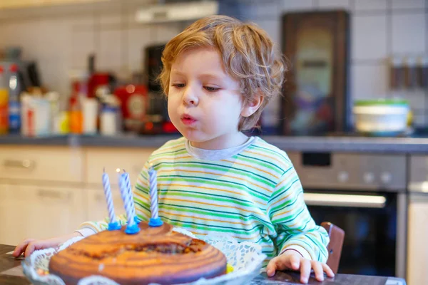Little kid boy celebrating his birthday and blowing candles on cake — Stock Photo, Image