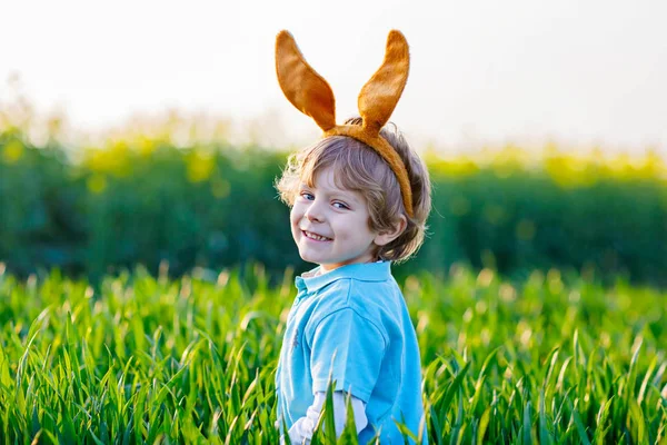 Niño divirtiéndose con la tradicional caza de huevos de Pascua —  Fotos de Stock