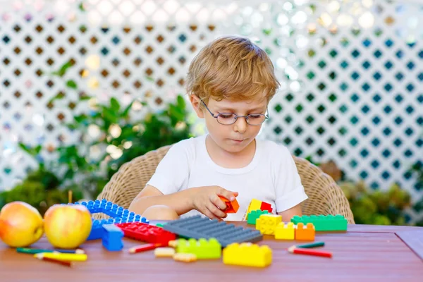 Kleine jongen jongen spelen met kleurrijke kunststof blokken — Stockfoto