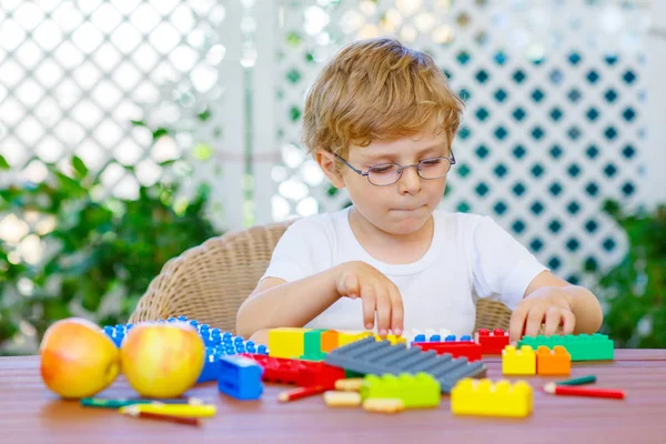 Menino brincando com blocos de plástico coloridos — Fotografia de Stock