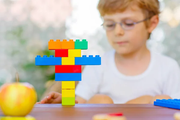 Liten unge pojke leker med färgglada plast block — Stockfoto