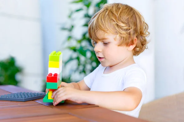 Kleine jongen jongen spelen met kleurrijke kunststof blokken — Stockfoto